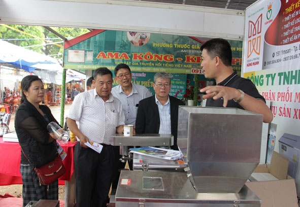 Giám đốc các hợp tác xã nông nghiệp trên địa bàn tỉnh tìm hiểu công nghệ đóng gói sản phẩm ở Hội chợ Nông nghiệp và sản phẩm OCOP khu vực Tây Nguyên tại Đắk Lắk.