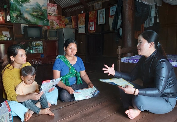 Nữ hộ sinh Nguyễn Thị Hiền (bìa phải) tuyên truyền, hướng dẫn người dân cách chăm sóc sức khỏe.