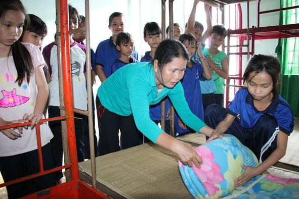 Cô Nguyễn Thị Hường hướng dẫn học sinh xếp tư trang trong phòng ở.