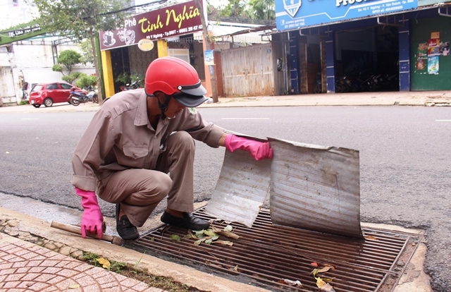 Công nhân Xí nghiệp thoát nước Buôn Ma Thuột (Công ty Cổ phần Đô thị và Môi trường Đắk Lắk) vệ sinh nắp cống trên các tuyến đường.