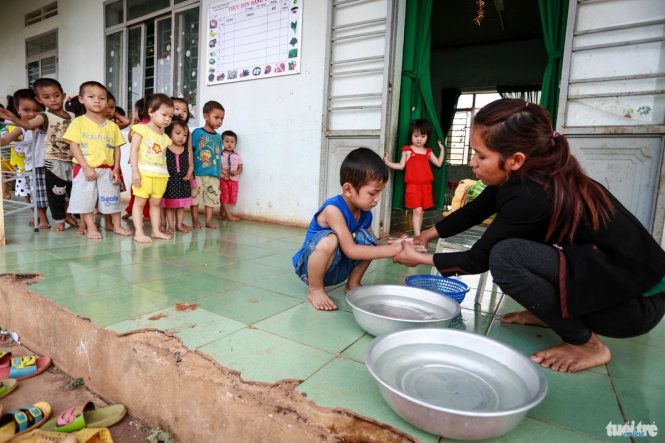 Cô giáo H Moar phân hiệu trường mầm non Hoa Hồng (xã Ea Sin, huyện Krông Búk) rửa tay cho từng học sinh. (Ảnh: T. Trẻ))