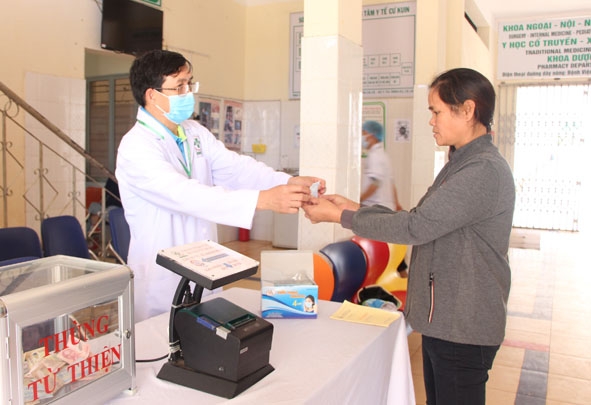 Cán bộ Trung tâm Y tế huyện Cư Kuin phát khẩu trang miễn phí và hướng dẫn người dân cách sử dụng. 