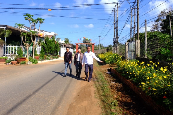 Bí thư Đảng ủy, Chủ tịch UBND xã Hòa Đông Nguyễn Đình Vượng (bìa phải) kiểm tra phong trào xây dựng  các tuyến đường trồng hoa trên địa bàn.