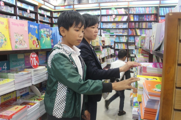 Phụ huynh và học sinh lựa chọn mua sách giáo khoa.  