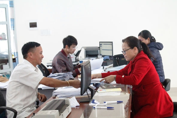 Cán bộ BHXH huyện Krông Ana giải quyết các thủ tục về bảo hiểm cho người dân.  