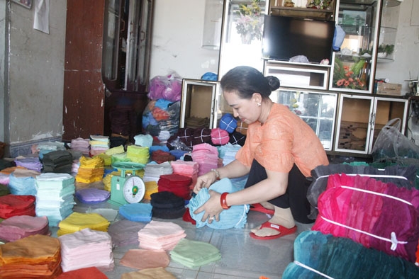 Chị Trương Vũ Kiều Loan (xã Hòa Khánh, TP. Buôn Ma Thuột) đóng vải đã cắt gửi đi cho thợ may gia  công.