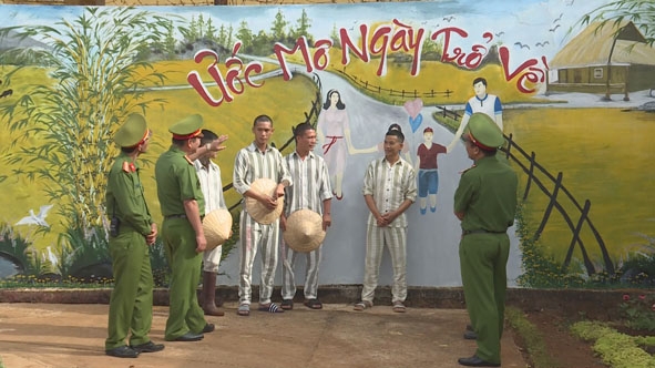 Cán bộ Trại giam Đắk Trung trò chuyện với các phạm nhân bên bức tranh tường ở phân trại 1.