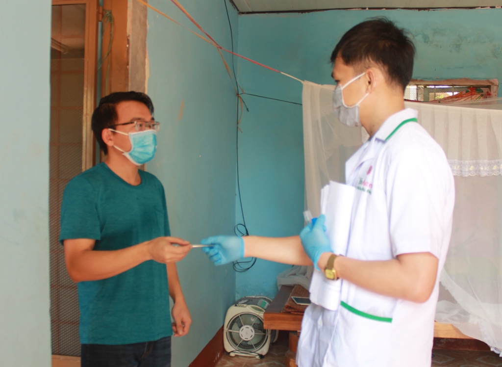 Cán bộ Trạm y tế phường Tự An (TP. Buôn Ma Thuột) theo dõi kiểm tra thân nhiệt cho người trở về từ quốc gia có dịch Covid-19 cách ly y tế tại nhà. 