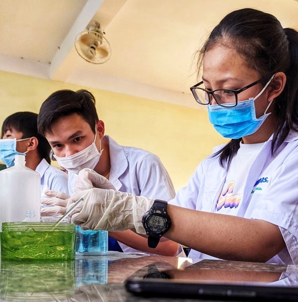 Các thành viên CLB STEM điều chế nước rửa tay diệt khuẩn tại phòng thí nghiệm của nhà trường.