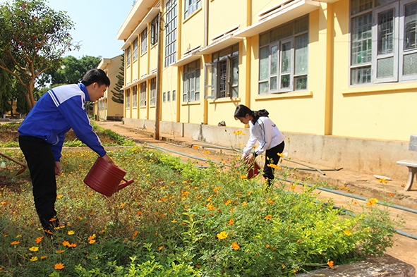 Học sinh Trường THPT Y Jút (huyện Cư Kuin) chăm sóc bồn hoa. 