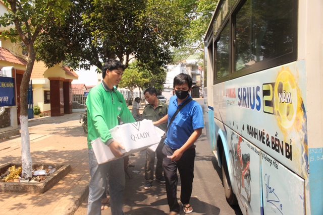 Nhân viên bán vé xe buýt (áo xanh) nhận hàng hóa tại trạm dừng đường Lê Hồng Phong. 