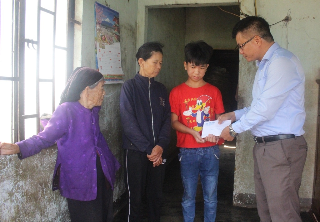 Hiệu trưởng Trường THCS Đoàn Kết Lê Văn Chính trao tiền hỗ trợ do Nhóm từ thiện huyện Cư Mgar vận động tặng gia đình em Đỗ Văn Quang.