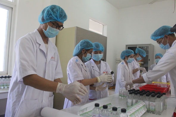 Sinh viên Trường Đại học Buôn Ma Thuột thực hiện công đoạn dán nhãn dung dịch rửa tay sát khuẩn. 