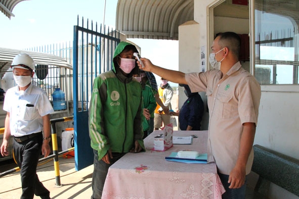 Nhân viên Chi nhánh Công ty Cổ phần Chăn nuôi CP Việt Nam huyện Ea Kar kiểm tra thân nhiệt  những người vào nhà máy.  