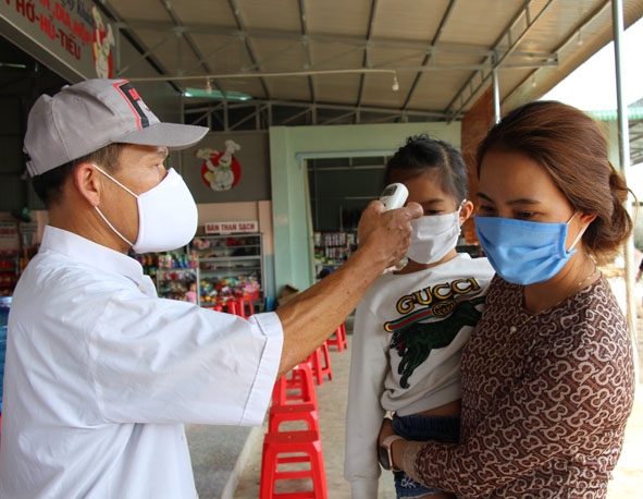 Cán bộ Trung tâm Y tế huyện Ea H’leo đo thân nhiệt cho người dân đi từ ngoài tỉnh vào.