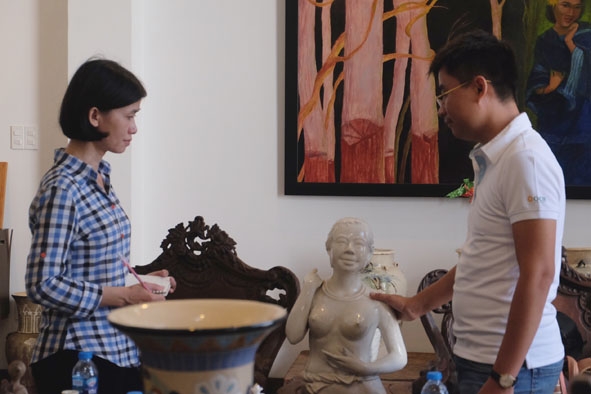 Nhà sưu tập Võ Minh Luân (bên phải) giới thiệu về bức tượng “Cô gái Tây Nguyên ngực trần mang gùi”.