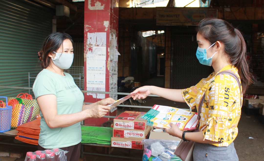 Cán bộ Trung tâm Kiểm soát bệnh tật tỉnh phát tờ rơi tuyên truyền phòng chống dịch Covid-19 cho người dân tại chợ Hòa Thuận (TP. Buôn Ma Thuột)