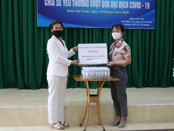 Đại diện Hội LHPN huyện Cư Kuin (bên phải) nhận khẩu trang vải và nước rửa tay sát khuẩn của Hội Nữ trí thức tỉnh trao tặng. 
