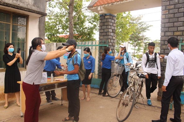 Trường THCS Hồ Tùng Mậu (xã Ea Wer, huyện Buôn Đôn) đo thân nhiệt, rửa tay sát khuẩn và tặng khẩu trang  cho học sinh ngay cổng trường.  