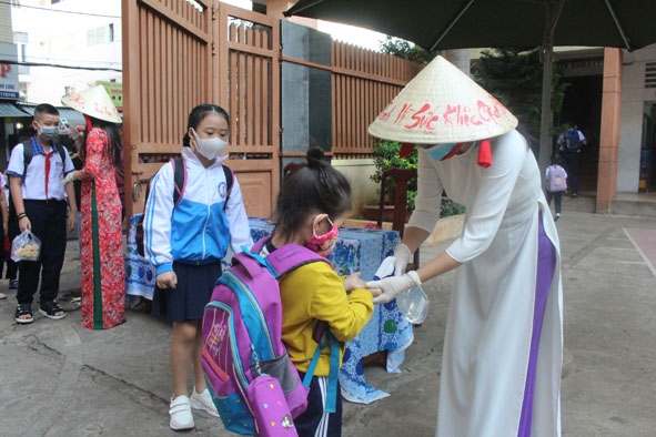 Giáo viên Trường Tiểu học Phan Chu Trinh (TP. Buôn Ma Thuột) rửa tay bằng dung dịch sát khuẩn cho học sinh trước khi vào lớp.  