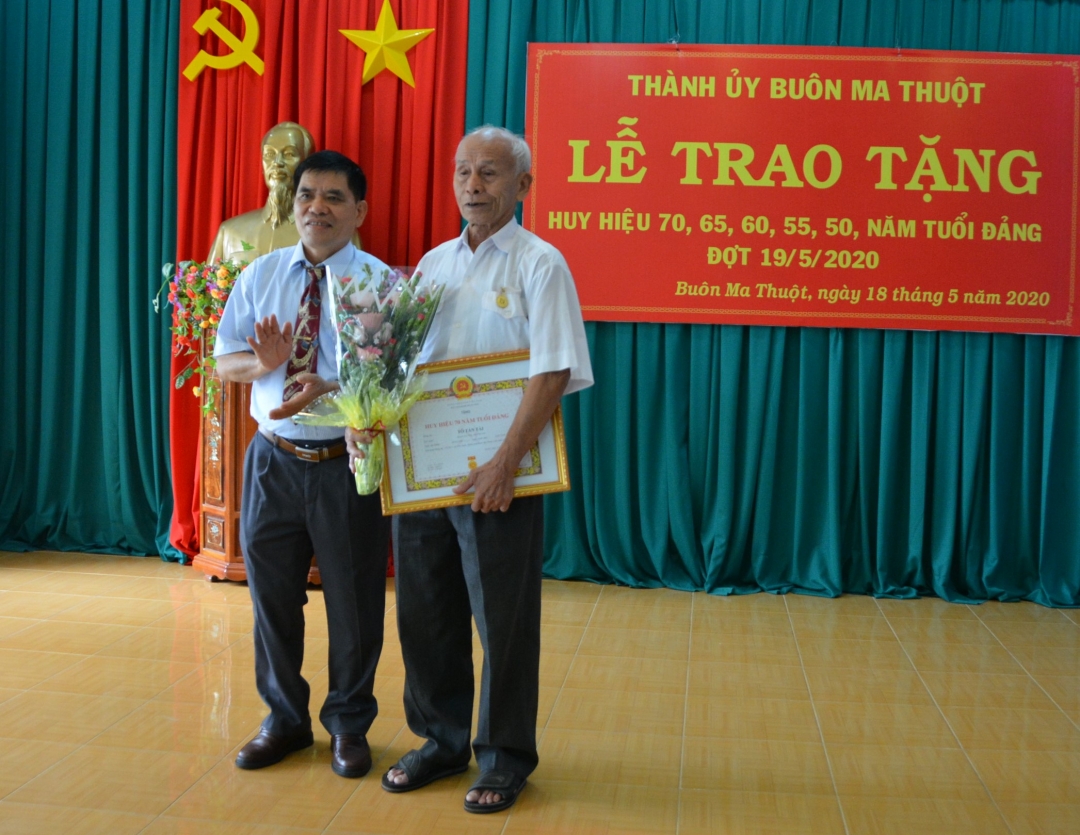Đồng chí Lê Năng Hảo, Phó Ban Tổ chức Tỉnh uỷ Đắk Lắk trao Huy hiệu đảng cho đảng viên 70 năm tuổi đảng