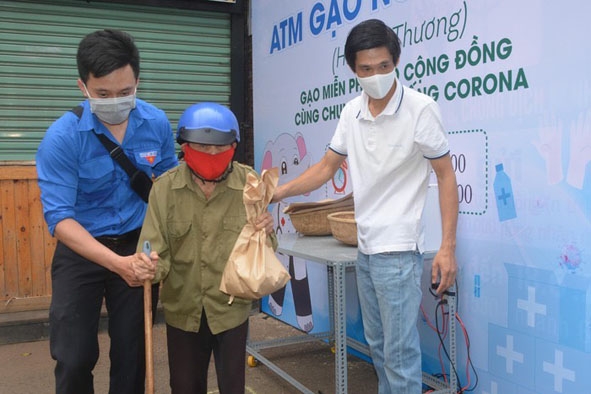 Đoàn viên thanh niên hỗ trợ người dân đến nhận gạo tại chương trình “ATM gạo nghĩa tình”. 