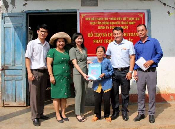 Lãnh đạo Thành ủy Buôn Ma Thuột và Đảng ủy phường Khánh Xuân trao kinh phí hỗ trợ sản xuất cho gia đình bà Dương Thị Toán.