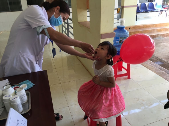 Bác sĩ ở Trạm Y tế xã Ea Kiết (huyện Cư M’gar) cho trẻ uống bổ sung vitamin A.  