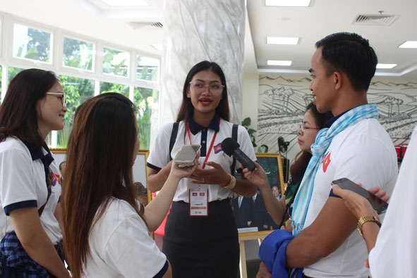 Các phóng viên trẻ Việt Nam cùng phỏng vấn một sinh viên tiêu biểu của nước bạn Campuchia  tại Ngày hội. 