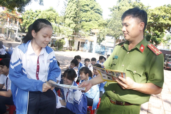 Cán bộ Công an TP. Buôn Ma Thuột phát tờ rơi cho học sinh Trường THCS Đoàn Thị Điểm.