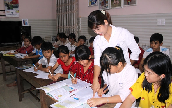 Cô Nguyễn Thị Thắm  (giáo viên Trường Tiểu học Ama Trang Lơng)  hướng dẫn các em học sinh học tiếng Anh. 