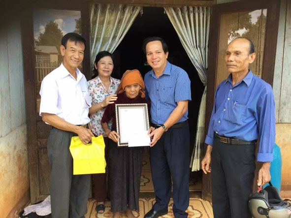Phó Bí thư Huyện ủy, Chủ tịch UBND huyện Cư M'gar Trương Văn Chỉ (thứ 2 từ phải sang) tặng quà một gia đình chính sách tại xã Ea Tul.