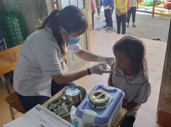 Tiêm vắc xin phòng bệnh bạch hầu cho trẻ 7 tuổi ở buôn Diêo.  