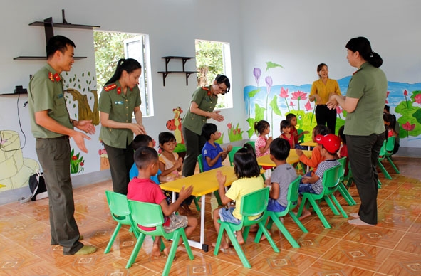 Cán bộ, chiến sĩ Phòng Quản lý xuất nhập cảnh (Công an tỉnh) cùng các em nhỏ buôn Hluch (xã Ea Kuêh, huyện Cư M'gar) trong ngày bàn giao lớp học 