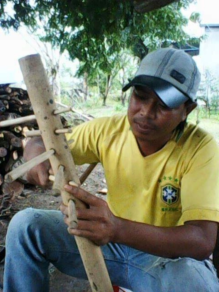 Anh Y Puen Niê đang chế tác nhạc cụ bằng tre nứa.