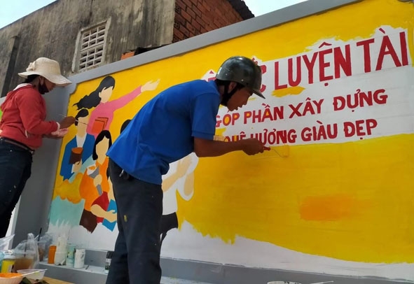 Tình nguyện viên tham gia vẽ tranh tường tại Trường THCS Phan Đình Phùng. 
