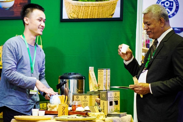 Giám đốc Công ty TNHH Nguyễn Văn Foods Nguyễn Văn Sơn (bên trái) giới thiệu sản phẩm Trà Mãng Cầu ở Hội chợ sản phẩm lên men quốc tế năm 2019 tại thành phố Jeonju, tỉnh Jeollabuk, Hàn Quốc. (Ảnh: Nhân vật cung cấp)