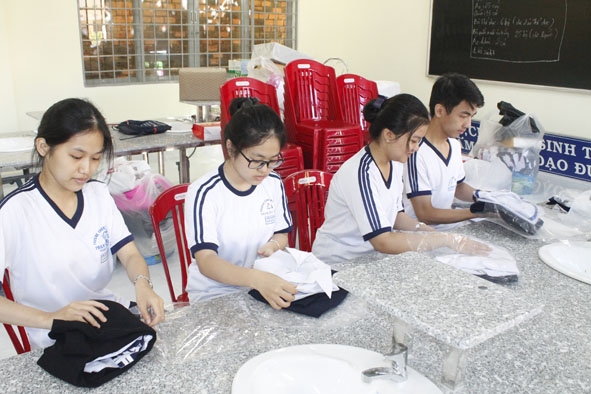 Học sinh  Trường THCS  Phạm Hồng Thái  gấp áo quần  tặng bạn nghèo.