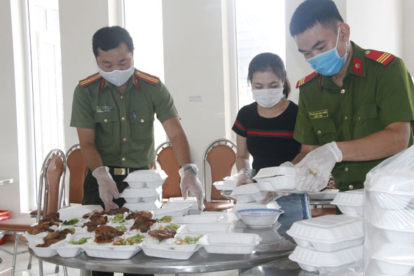 Cán bộ, chiến sĩ Công an tỉnh chuẩn bị suất ăn cho công dân khu cách ly tập trung vào tháng 8-2020. 