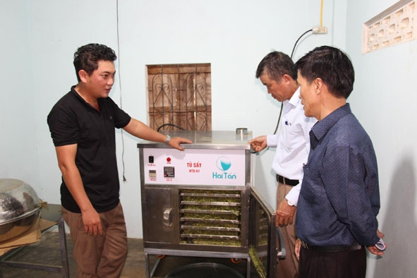 Anh Hoàng Văn Hiệu (bìa trái) thông tin về tình hình sản xuất của Hợp tác xã Nông nghiệp Dịch vụ Cao Bằng với cán bộ địa phương.