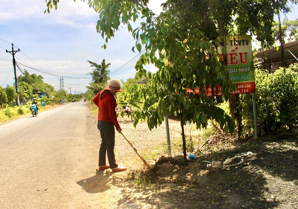 Hội viên phụ nữ thôn Tân Phú (xã Ea Nuôl) chăm sóc cây xanh trên tuyến đường nội thôn.