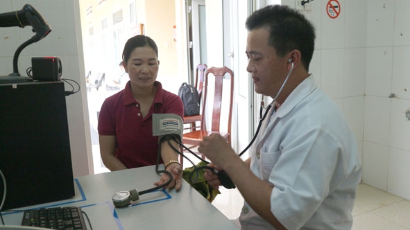        Nhân viên y tế  Trạm Y tế  xã Ea Ô  khám bệnh cho  người dân.   Ảnh:  Quang Nhật