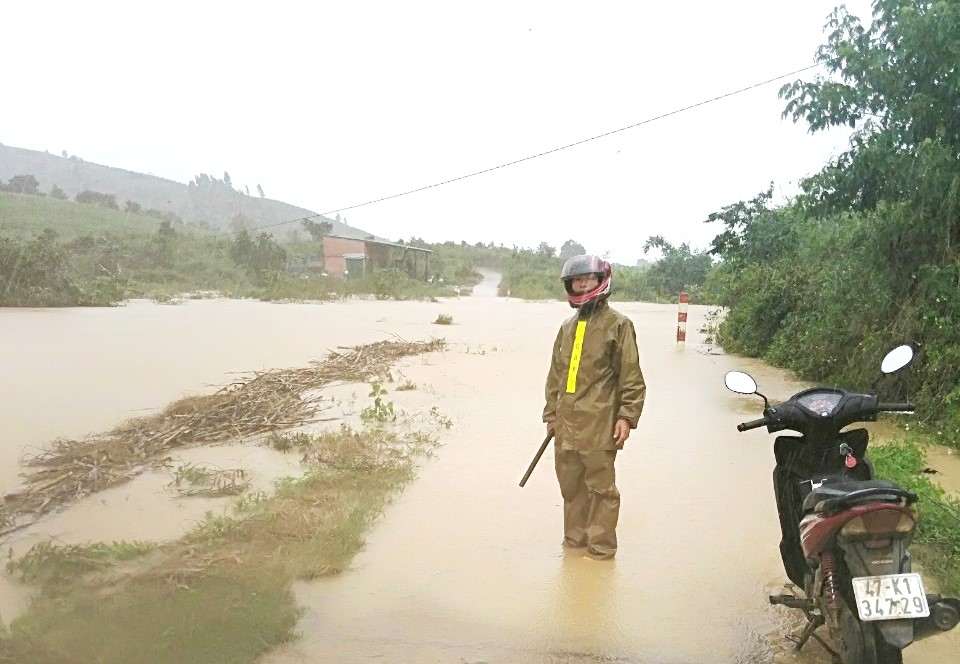 Lực lượng chức năng túc trực tại một đoạn đường bị ngập ở xã Cư Pui.