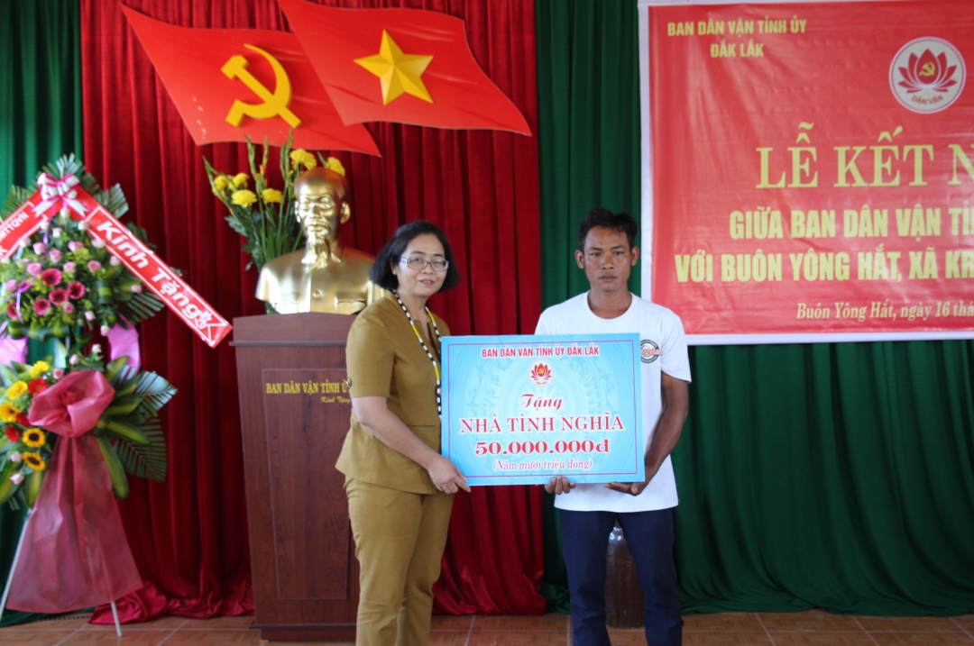 Đồng chí H’Kim Hoa Byă, Trưởng Ban Dân vận Tỉnh ủy, Chủ tịch Ủy ban Mặt trận Tổ quốc Việt Nam tỉnh trao biểu trưng nhà tình nghĩa tặng gia đình anh Y Ven BKrông.