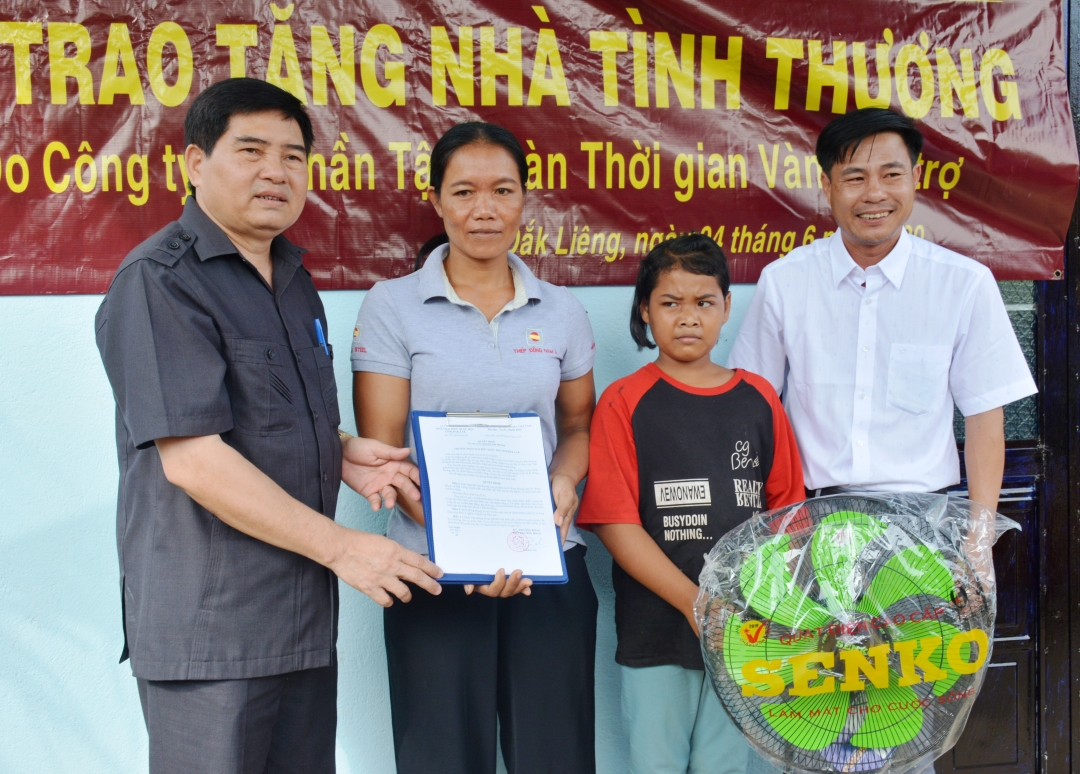 Phó trưởng Đoàn chuyên trách Đoàn ĐBQH tỉnh Y Khút Niê (bìa trái) bàn giao nhà Tình thương tặng gia đình  chị H’Wing Byang ở buôn Bàng (xã Đắk Liêng, huyện Lắk). 