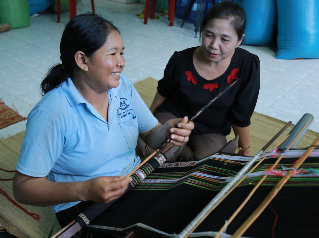 Chi H'Yăm Bkrông (bên trái) chia sẻ về việc giữ gìn nghề dệt truyền thống. 