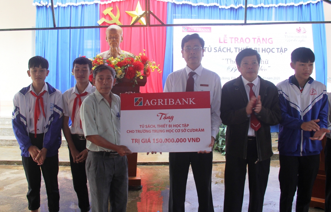 Đại diện Agribank Đắk Lắk trao tặng tượng trưng các thiết bị, tủ sách cho Trường THCS Cư Drăm