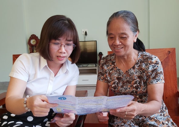 Cán bộ BHXH huyện Lắk tuyên truyền cho người dân trên địa bàn về lợi ích khi tham gia BHXH tự nguyện. 
