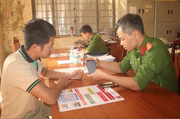Thiếu tá Đoàn Văn Tương, Phó Trưởng Công an xã Ea Wer hướng dẫn người dân kết nối  với Zalo của Công an xã. 