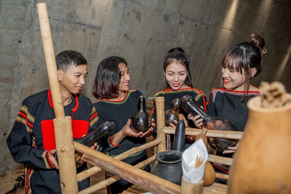 Chị H’Tit Aliô (thứ hai từ trái sang) cùng các bạn thanh niên tìm hiểu về các vật dụng truyền thống. Ảnh: Bảo tàng Thế giới cà phê